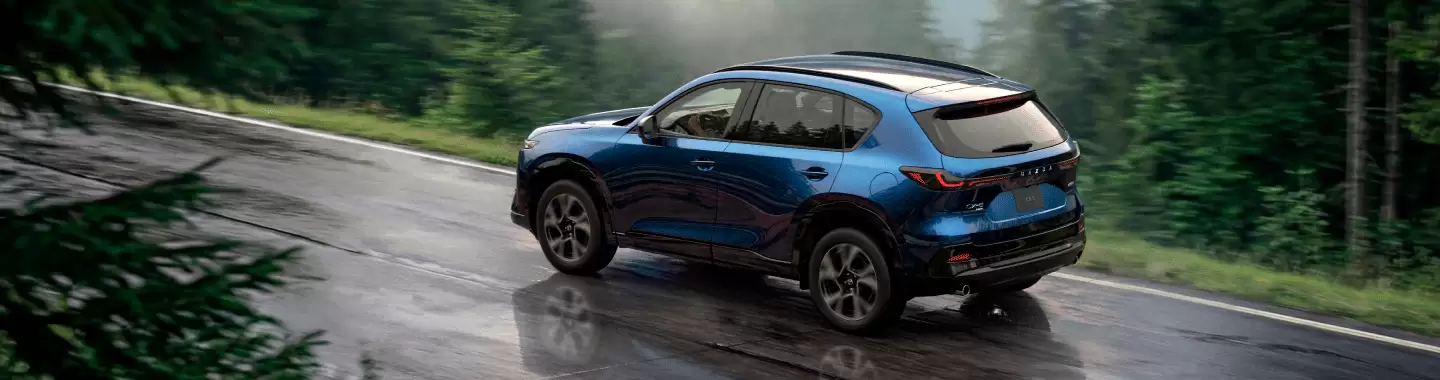 Nuevo Mazda CX-5 2027 azul con tracción AWD en camino mojado